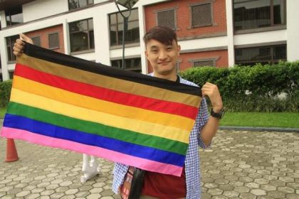 Tashi Tsheten, zet zich met COC in voor voor de mensenrechten van lhbti+ in Buthan, Zuid-Azië. Hij houdt hier de regenboogvlag vast.